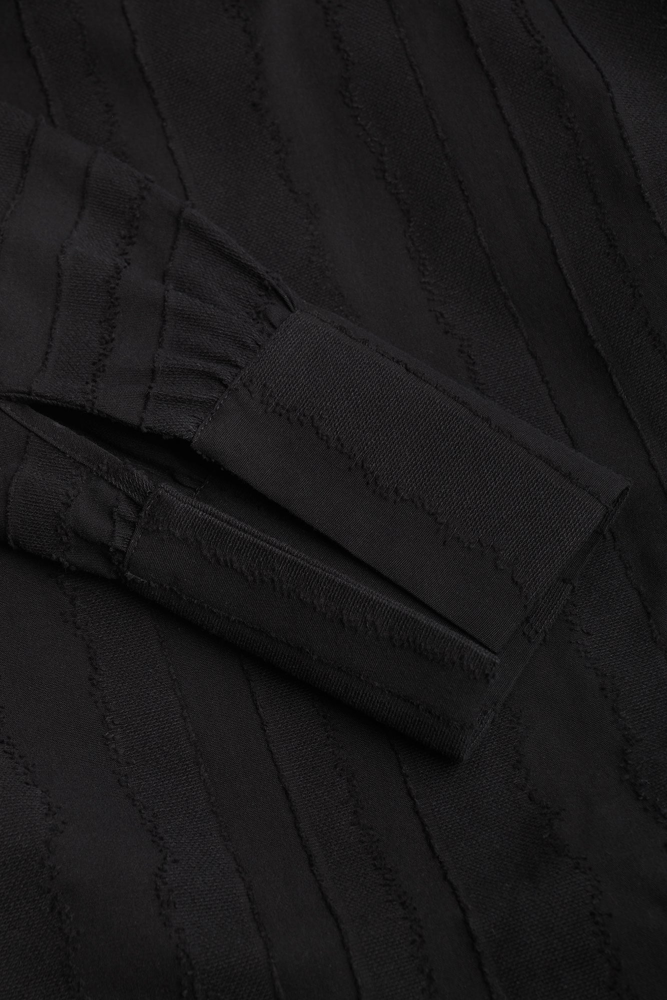 Close-up of black textured fabric with a pocket